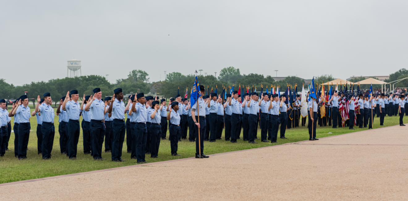 Airmen salute an American flag