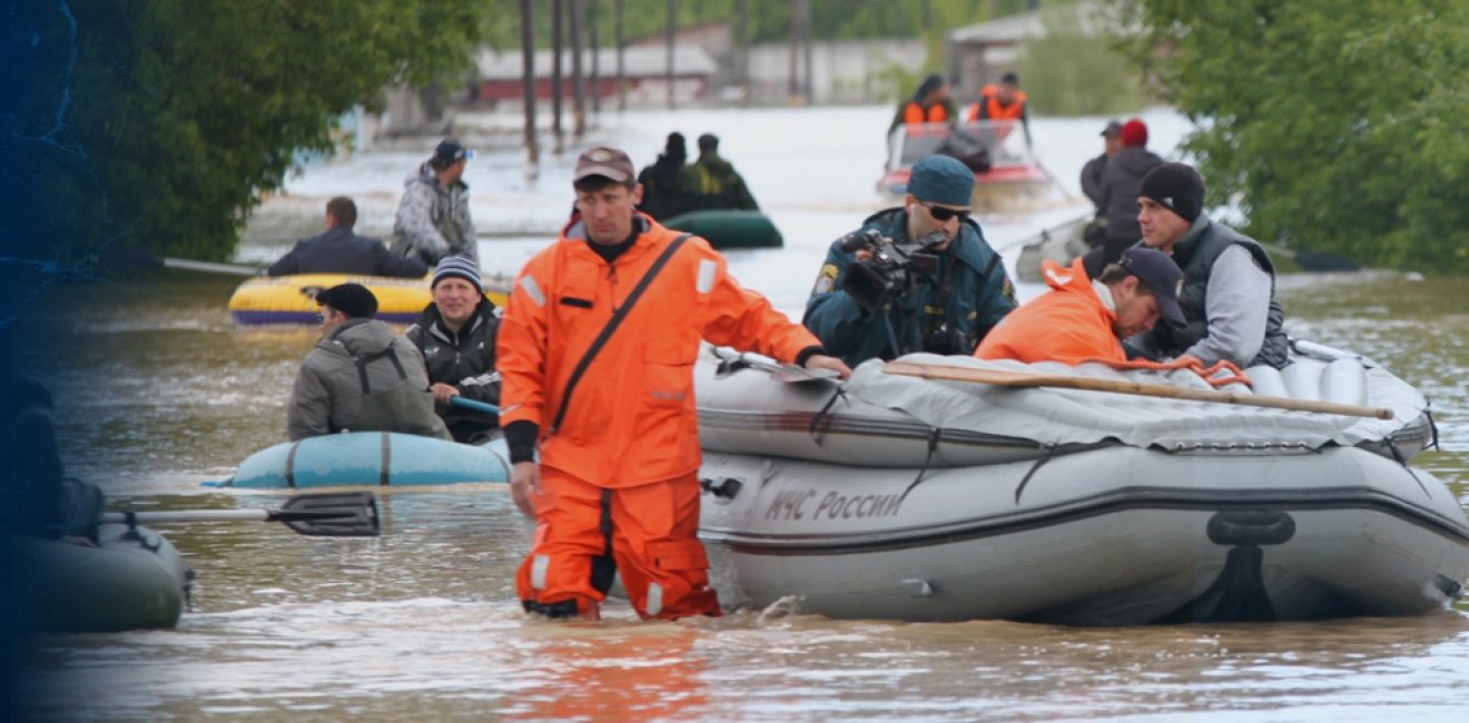 Man walking in knee-high water pulling a raft with people in it