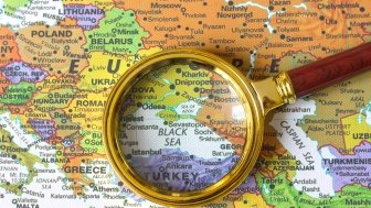 A looking glass centered over a map of the Black Sea.