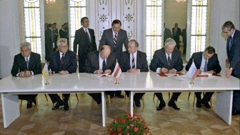 Ukrainian President Leonid Kravchuk (second from left seated), Chairman of the Supreme Council of the Republic of Belarus Stanislav Shushkevich (third from left seated) and Russian President Boris Yeltsin (second from right seated) during the signing ceremony to eliminate the USSR and establish the Commonwealth of Independent States. Viskuly Government House in the Belorusian National Park "Belovezhskaya Forest".