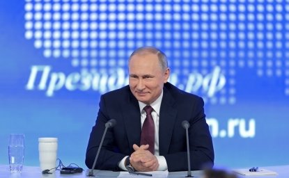 Image of Vladimir Putin smiling while taking questions