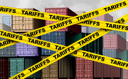 Yellow tape that reads 'tariffs' crosses in front of shipping containers