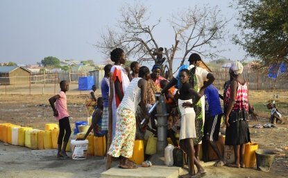 Juba, South Sudan, February 2017. People with yellow jerrycans waiting for water at a borehole site. Salesian camp for internally displaced persons (IDPs). Captured during civil war.