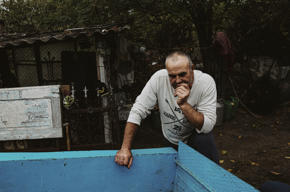 Ukrainian man leaning over blue trough