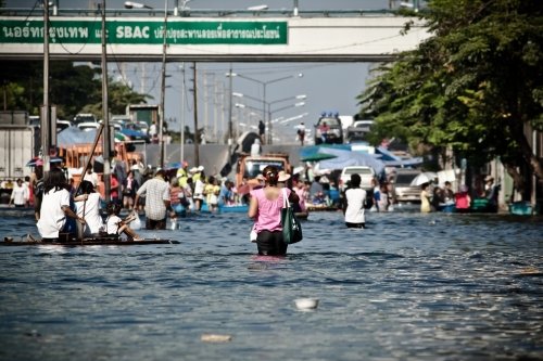 People walking down a flooded street
