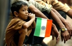 A young Indian boy with a flag from his country.