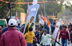 Indian citizens parade in the street holding India flags and images of President Modi