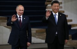 Russian President Vladimir Putin and Chinese President Xi Jinping wave while standing next to each other