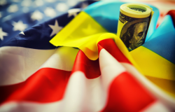 American and Ukrainian flags with a roll of American dollars