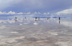 People standing salt flats in Bolivia where lithium lies underneath.