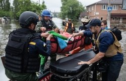 KHERSON, UKRAINE – Jun. 12, 2023: Lifeguards and volunteers seen evacuating helpless old people from flooded areas on stretchers,